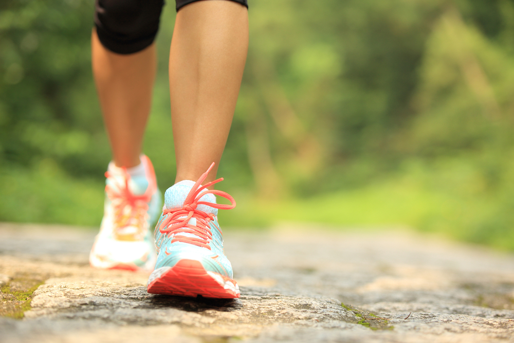 Close up on woman's trainers walking to show exercise benefits