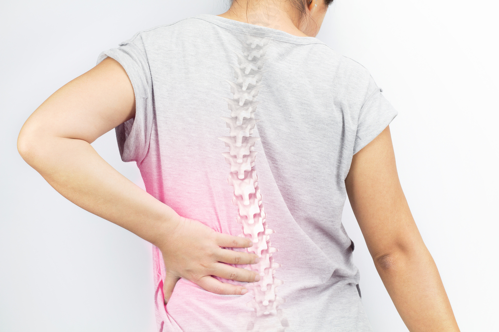 Close up on woman's back showing spinal column to represent back pain