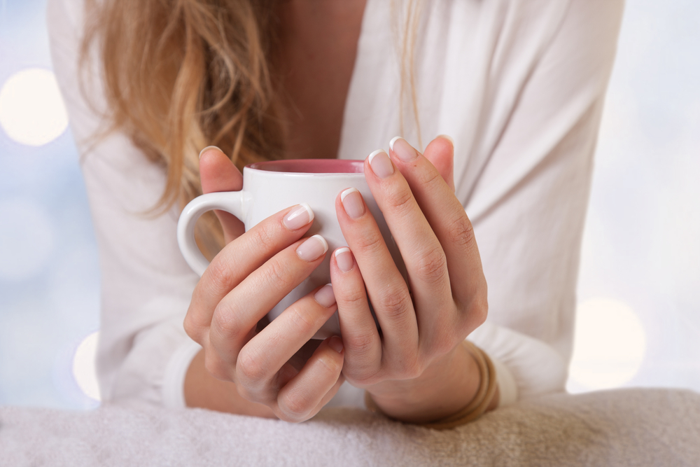 Close up on woman holding a mug of warm milk