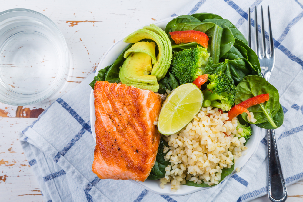 PLate of food including salmon, rice and salad to represent a balanced meal and diet