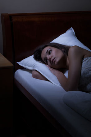 Woman awake in bed unable to get to sleep