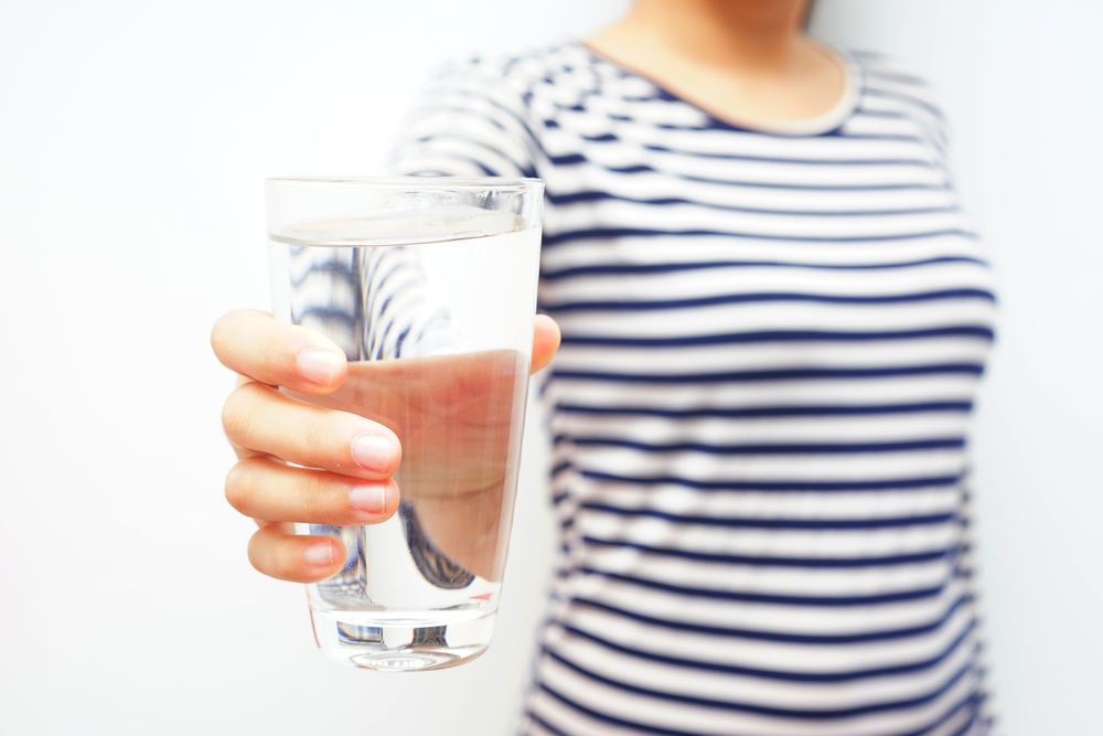 Close up of woman holding a glass of water