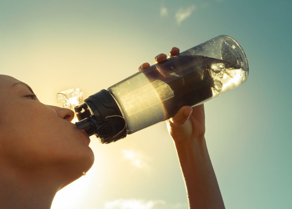 Close up of woman drinking water from a sports bottle after a work out