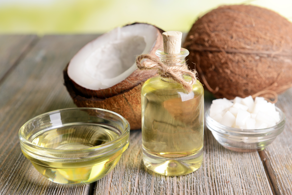 A fresh coconut, coconut flesh and coconut oil on a wooden background