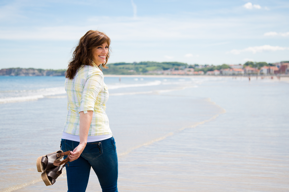 MIddle aged woman happy taking a stroll by the sea