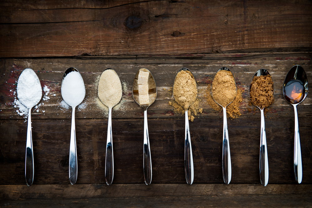 A range of different sugar types on spoons
